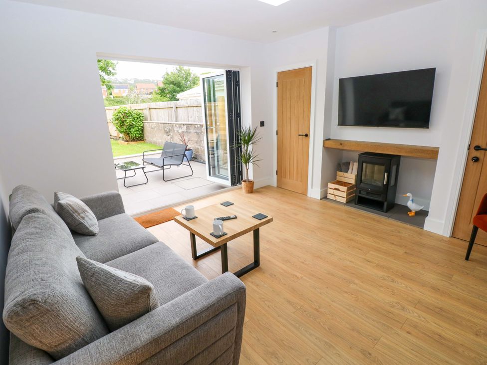 A living room with a sofa and coffee table at Y Bwthyn in Burry Port