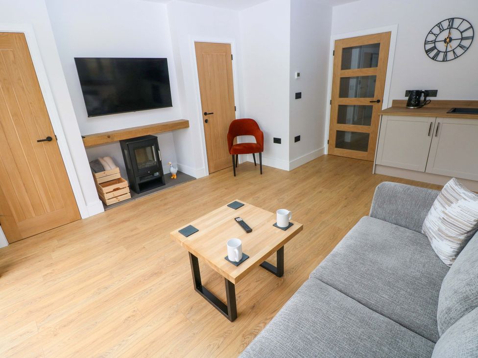 A living room with a television and fireplace at Y Bwthyn in Burry Port