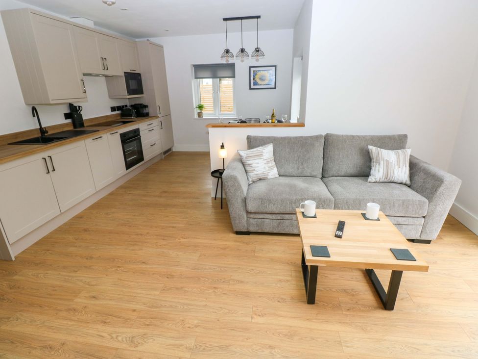 An open plan living area with a sofa and coffee table at Y Bwthyn in Burry Port