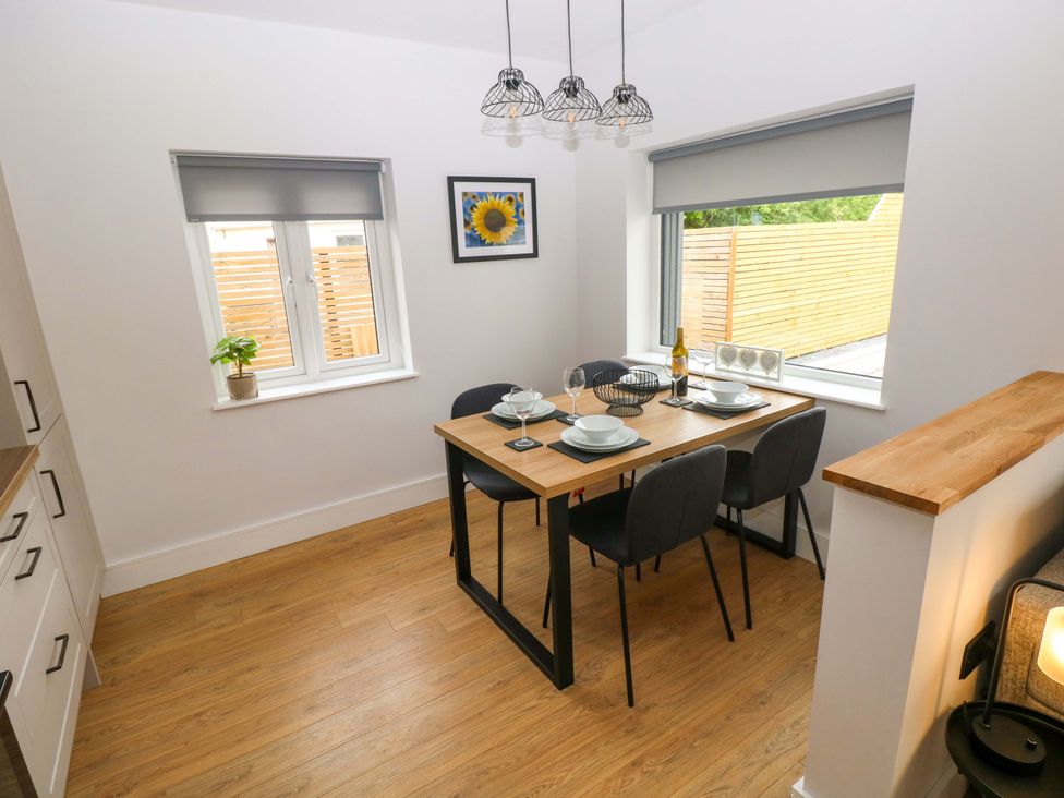 A dining room with a table and chairs at Y Bwthyn Burry Port