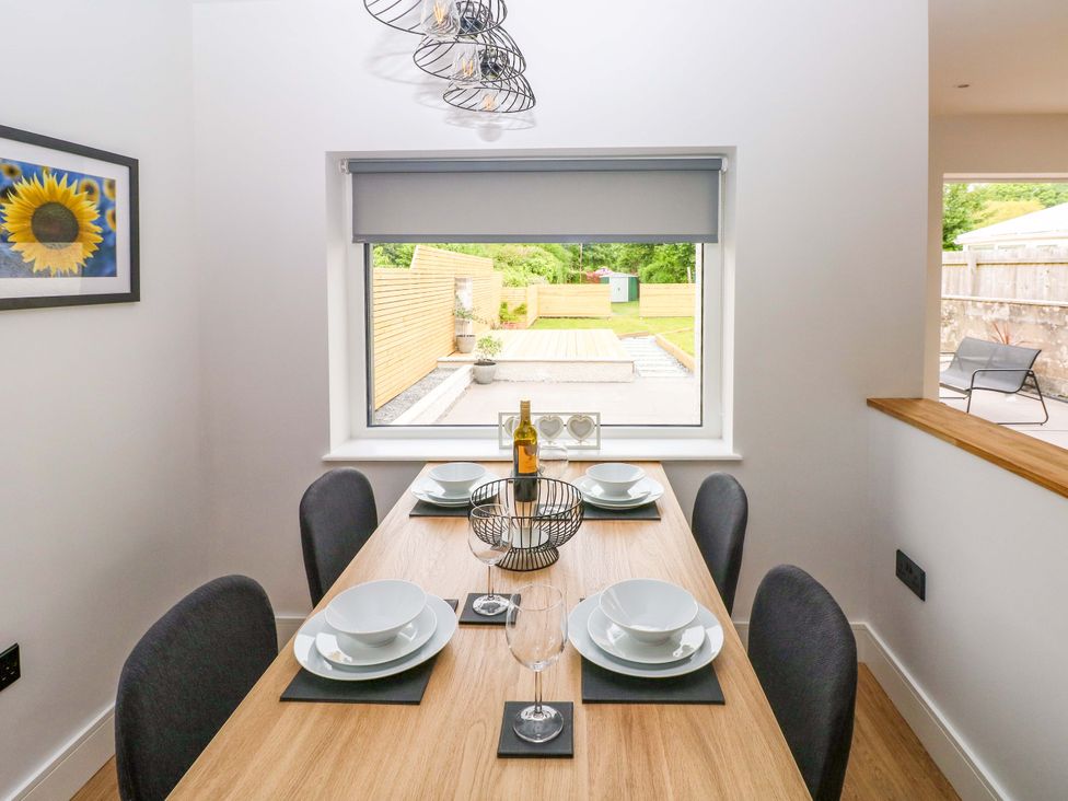 A dining room with a table set for dinner at Y Bwthyn Burry Port