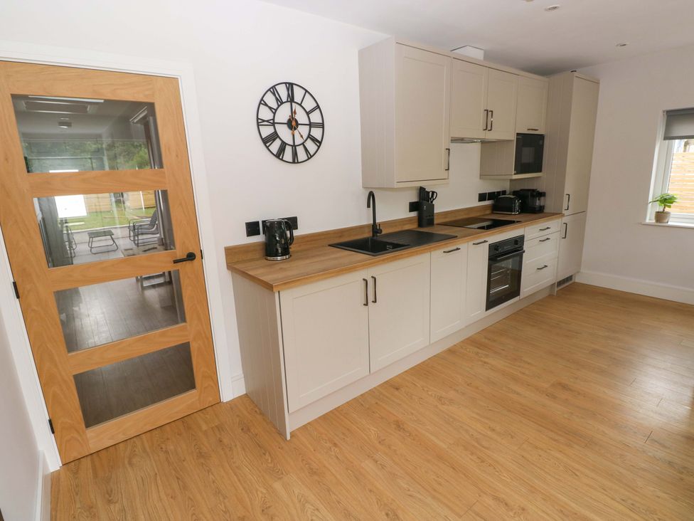 A kitchen with a sink and appliances at Y Bwthyn in Burry Port