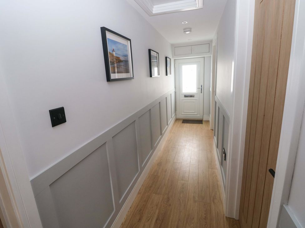 A hallway with pictures framed on the wall at Y Bwthyn in Burry Port