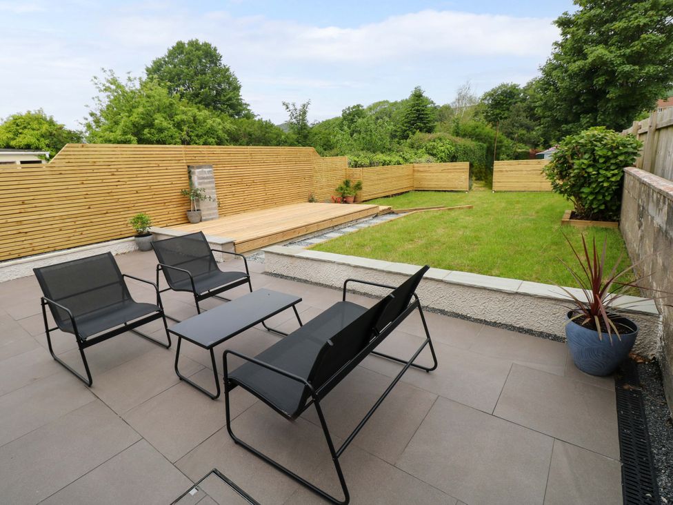 A garden with seating area and grass at Y Bwthyn in Burry Port