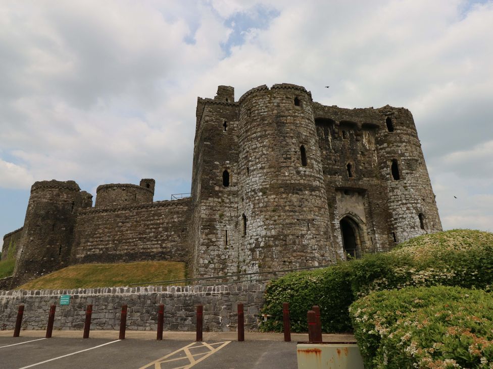 A castle with towers and walls in a parking area at Y Bwthyn in Burry Port