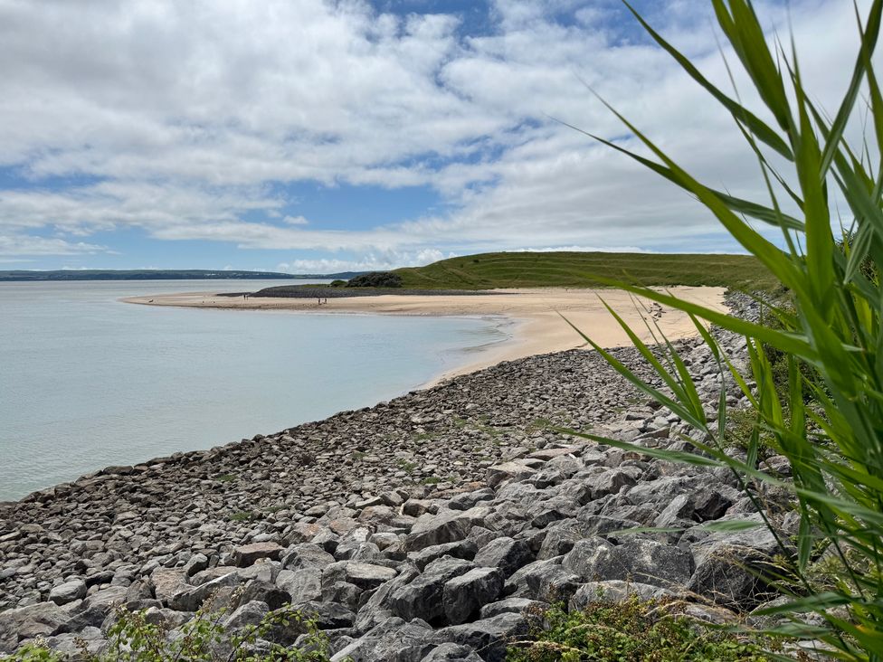 A beach with sand and rocks at Y Bwthyn Pembrey