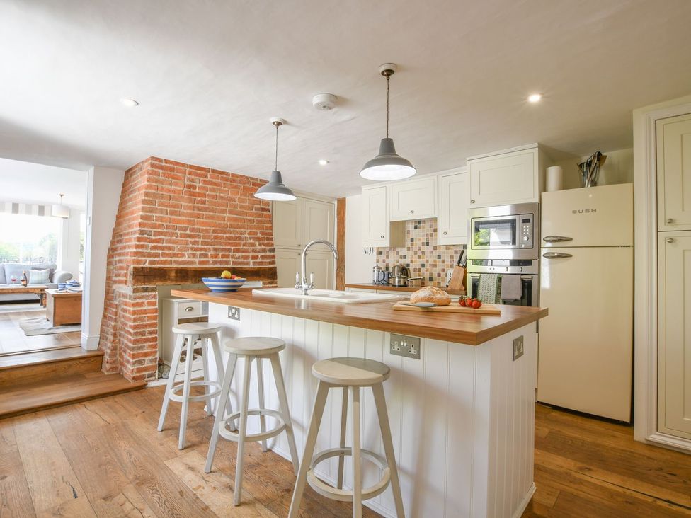 A kitchen with a kitchen island and stools at Beresford House in Woodbridge