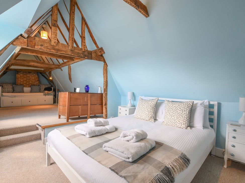 A bedroom with a bed and a sitting area at Beresford House in Woodbridge