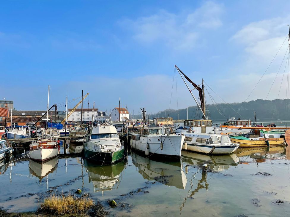 A harbor with moored boats and a crane at Beresford House in Woodbridge
