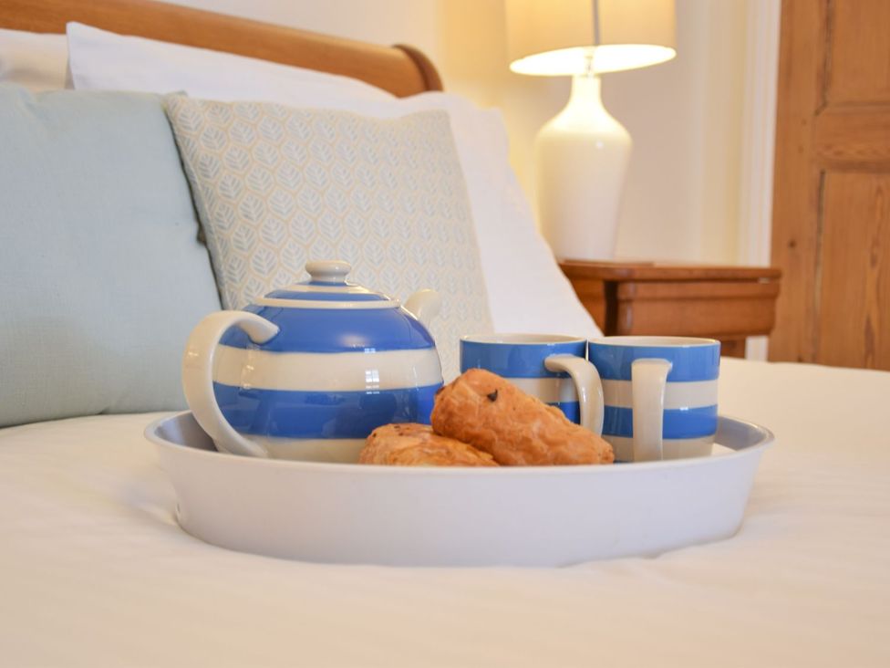 A tray with a teapot and cups on a bed at Beresford House in Woodbridge