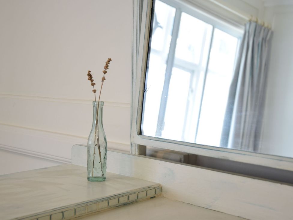 A table with a vase of dried flowers and a mirror at Beresford House in Woodbridge