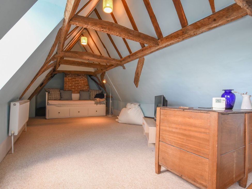 An attic with a sofa and wooden furniture at Beresford House in Woodbridge