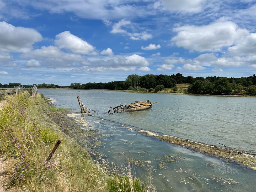 A river with an abandoned boat and grass at Beresford House in Woodbridge