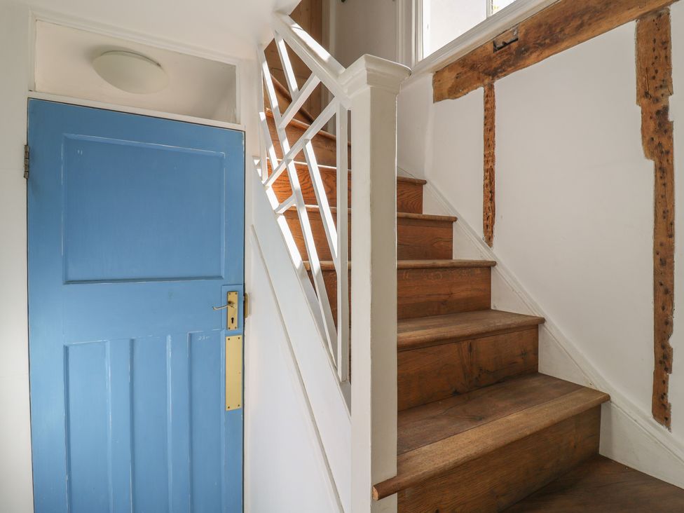 A staircase with wooden steps and a blue door at Beresford House in Woodbridge