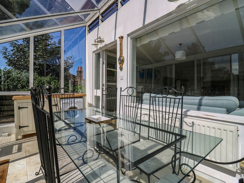 A conservatory with a glass table and chairs at Beresford House in Woodbridge