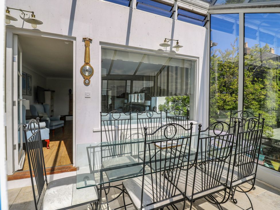 A conservatory with a glass dining table and chairs at Beresford House in Woodbridge