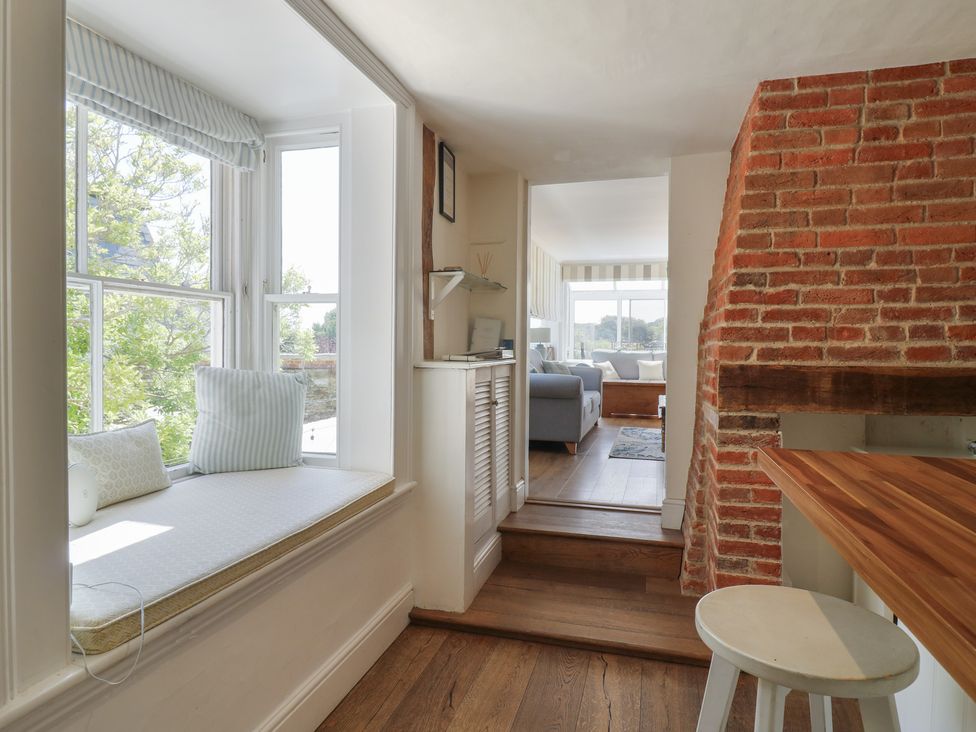 A living room with a window seat and wooden stairs at Beresford House in Woodbridge