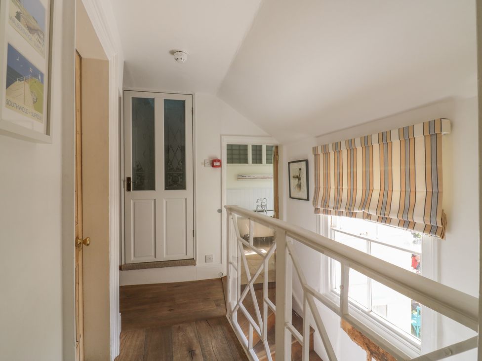 A hallway with a railing and a door at Beresford House in Woodbridge