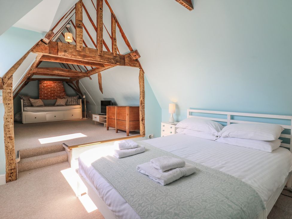 A bedroom with a bed and sofa at Beresford House in Woodbridge