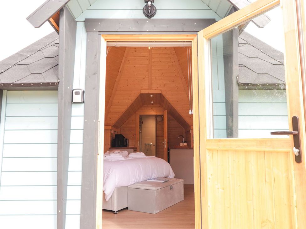 A studio with a bed and kitchenette visible from the entrance at Little Luxe Lodges 1 in Kyle