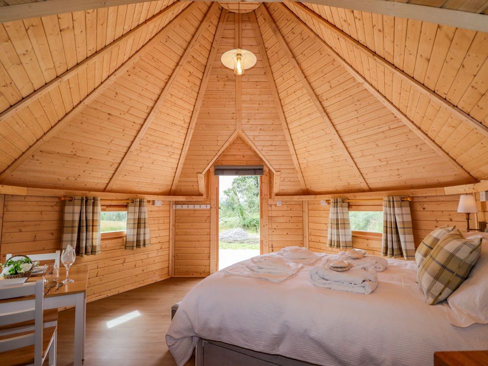 A bedroom with a bed and a table in Little Luxe Lodges 1 Kyle