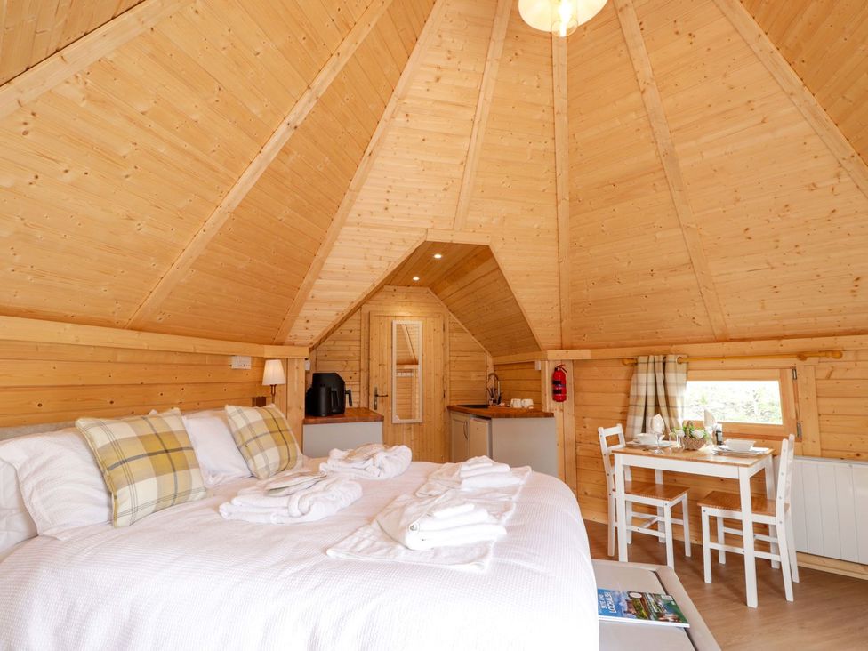 A bedroom with a bed, kitchenette, and dining table at Little Luxe Lodges 1 in Kyle
