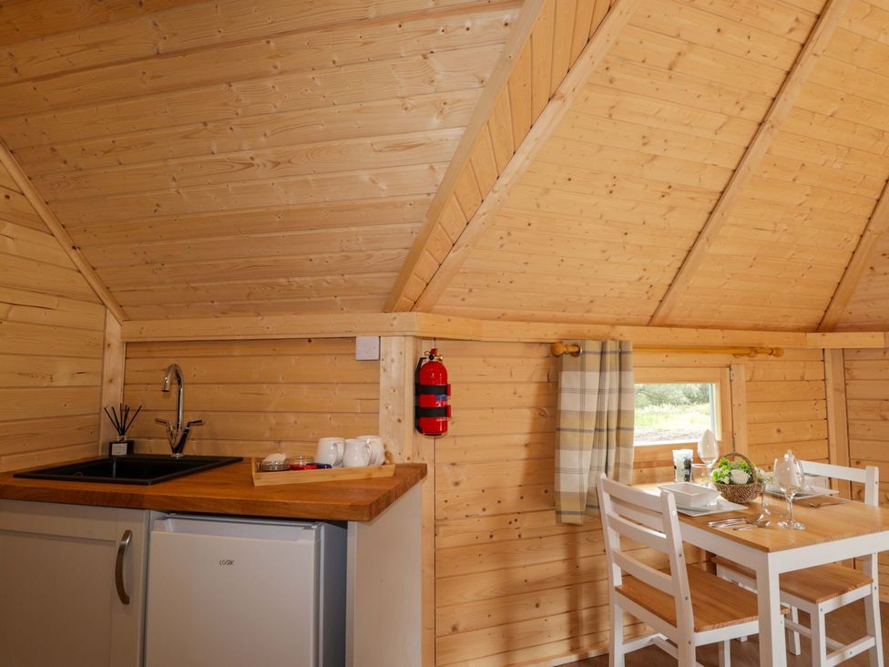 A kitchen with sink and dining table at Little Luxe Lodges 1 in Kyle