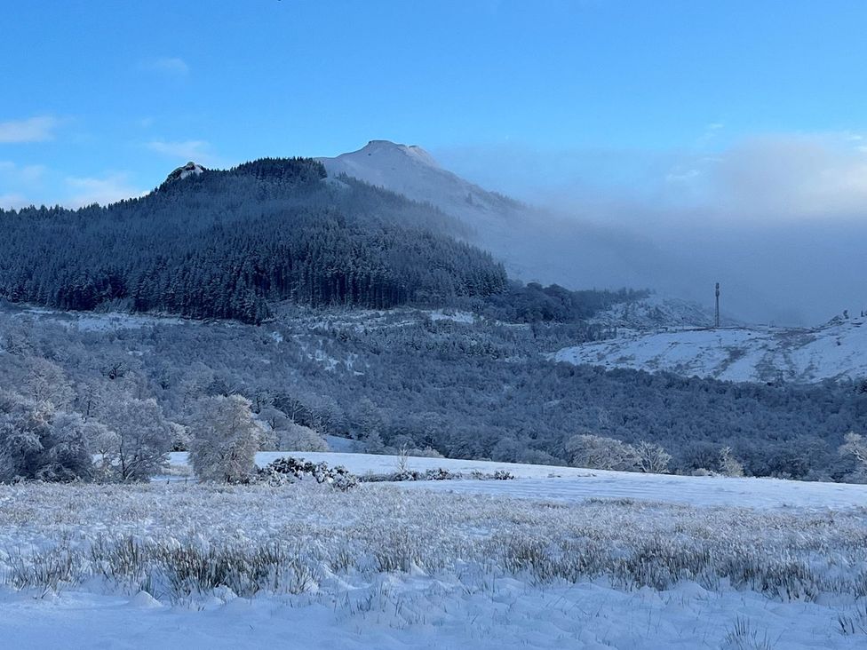 A snowy landscape with mountains and trees at Little Luxe Lodges 1 in Kyle