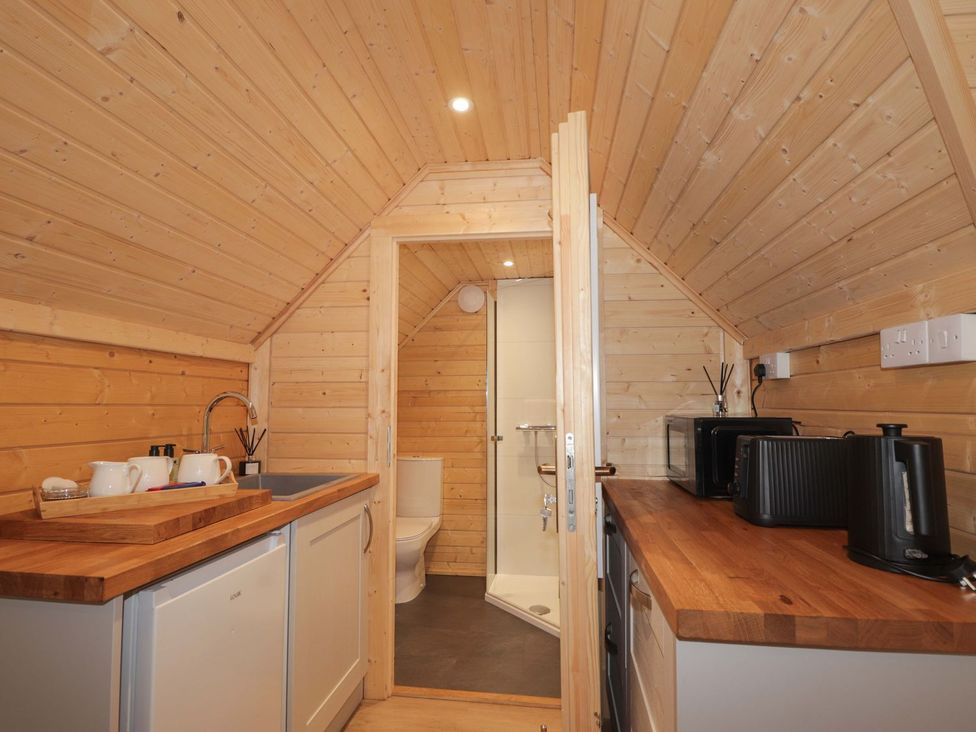 A kitchen with appliances and a bathroom visible in Little Luxe Lodges 2 in Kyle