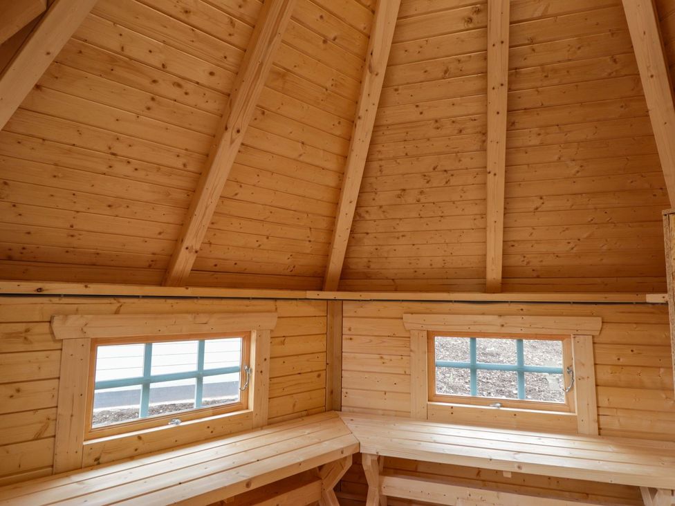 An indoor space with wooden walls, a wooden ceiling, and windows at Little Luxe Lodges 2 in Kyle