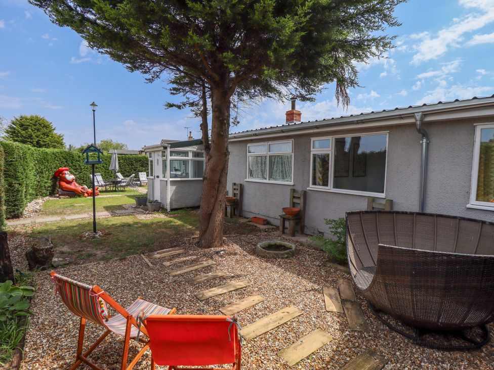 A garden with chairs and a table at Four Seasons in Humberston, Lincolnshire