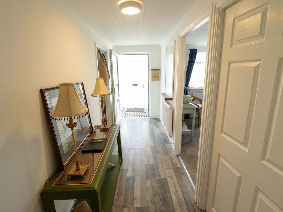 A hallway with a console table and two lamps at Four Seasons, Humberston, Lincolnshire