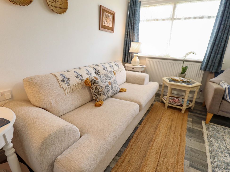 A living room with a sofa and lamp at Four Seasons in Humberston, Lincolnshire