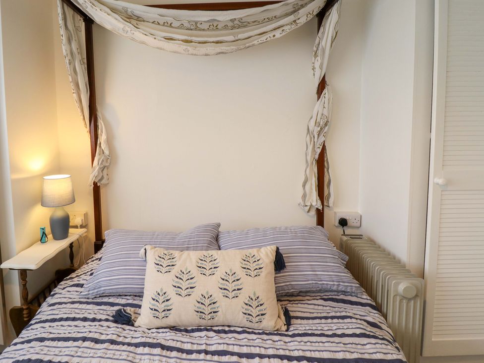 A bedroom with a bed and a lamp at Four Seasons in Humberston, Lincolnshire