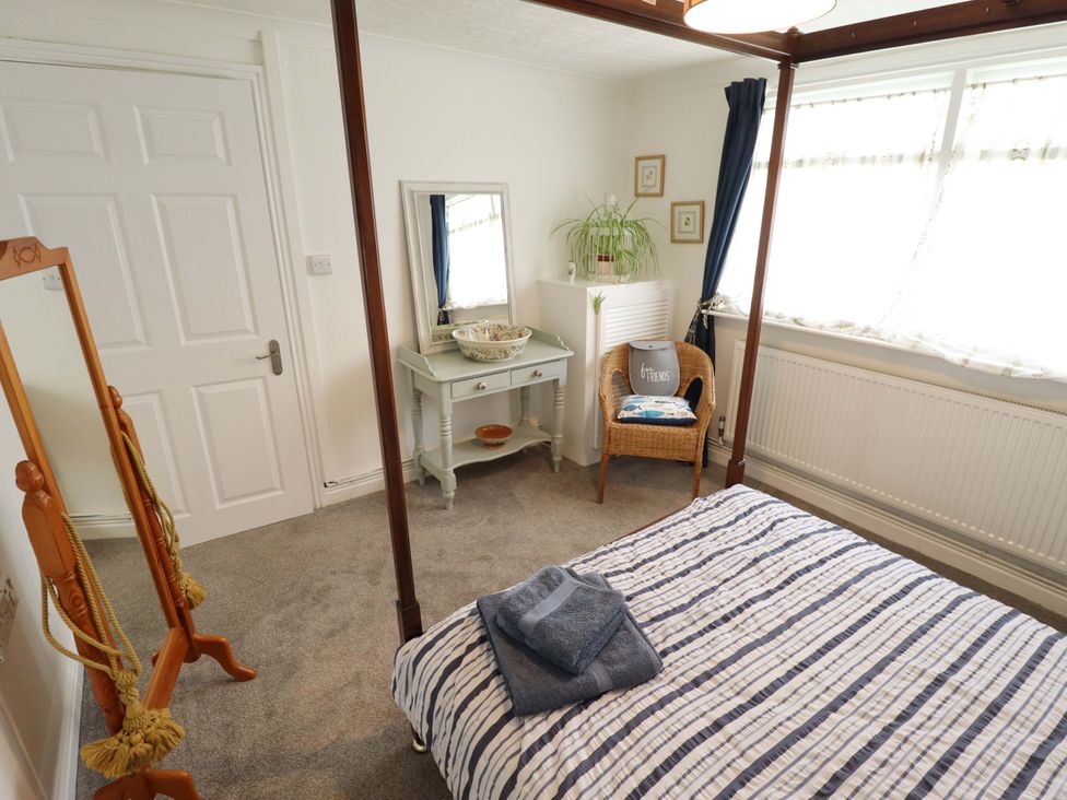 A bedroom with a bed and mirror at Four Seasons in Humberston, Lincolnshire
