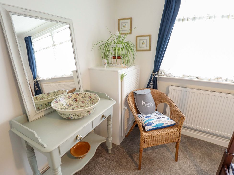A sitting room with a mirror, bowl, and chair at Four Seasons in Humberston, Lincolnshire