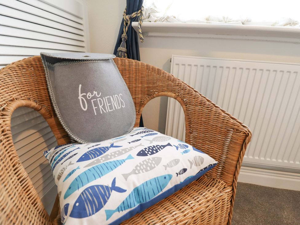 A chair with a cushion and a radiator in the sitting room at Four Seasons Humberston Lincolnshire
