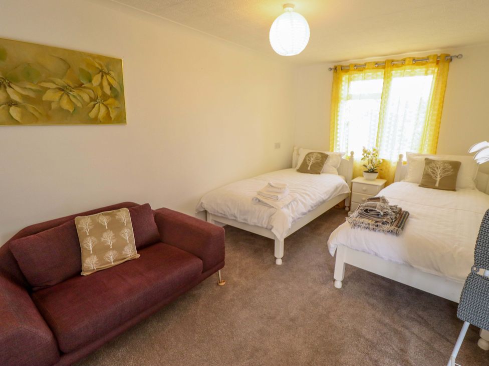 A bedroom with two beds and a sofa at Four Seasons in Humberston, Lincolnshire