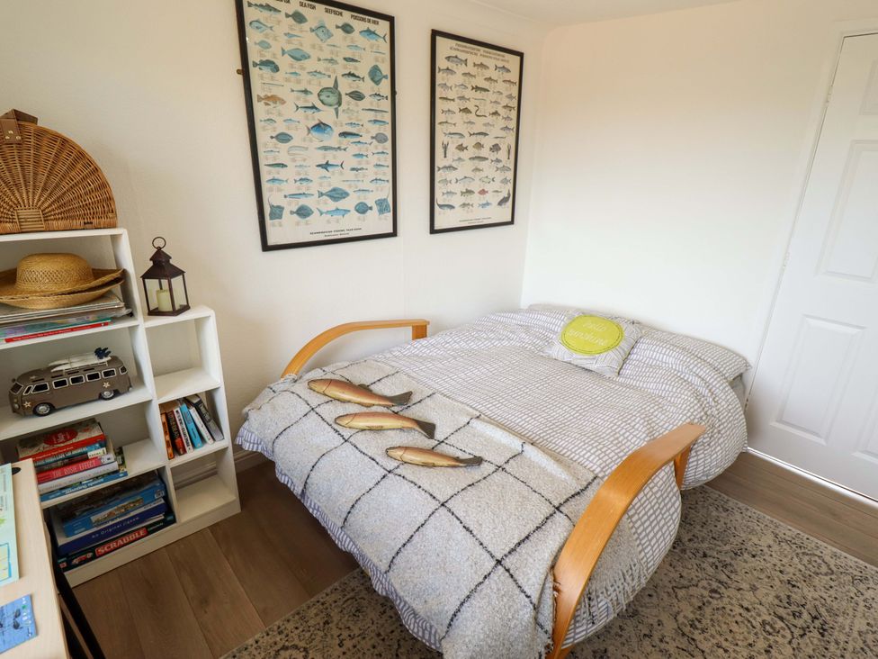 A bedroom with a bed and bookshelf at Four Seasons in Humberston, Lincolnshire