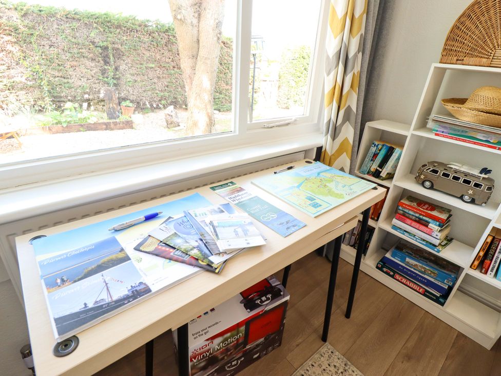 A study room with a desk and shelving containing books at Four Seasons in Humberston, Lincolnshire