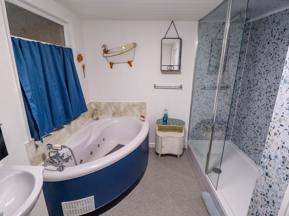 A bathroom with a bathtub and shower enclosure at Four Seasons in Humberston, Lincolnshire