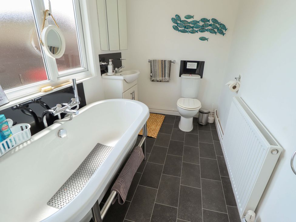 A bathroom with a bathtub and toilet at Four Seasons in Humberston, Lincolnshire