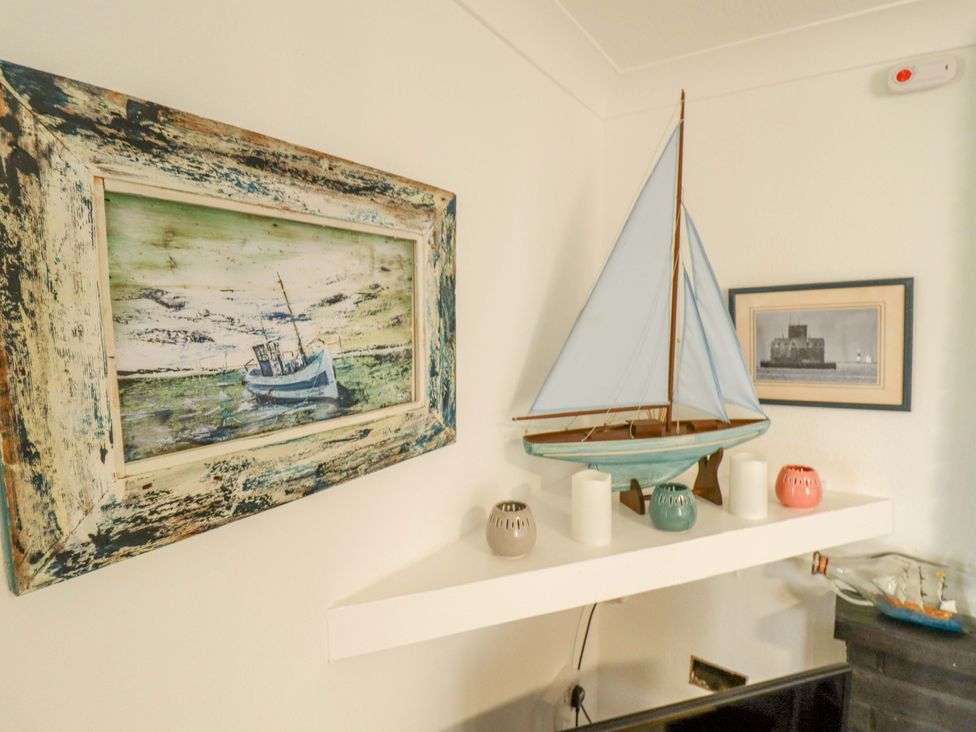 A living room with a sailboat model and pictures at Four Seasons Humberston, Lincolnshire