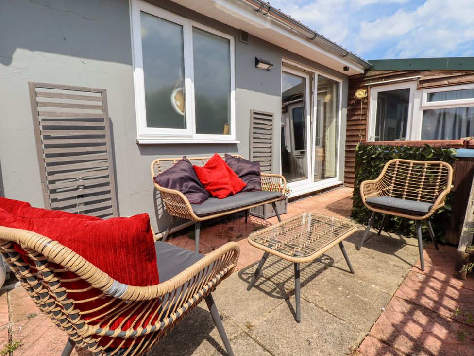 An outdoor seating area with chairs and a table at Four Seasons in Humberston, Lincolnshire