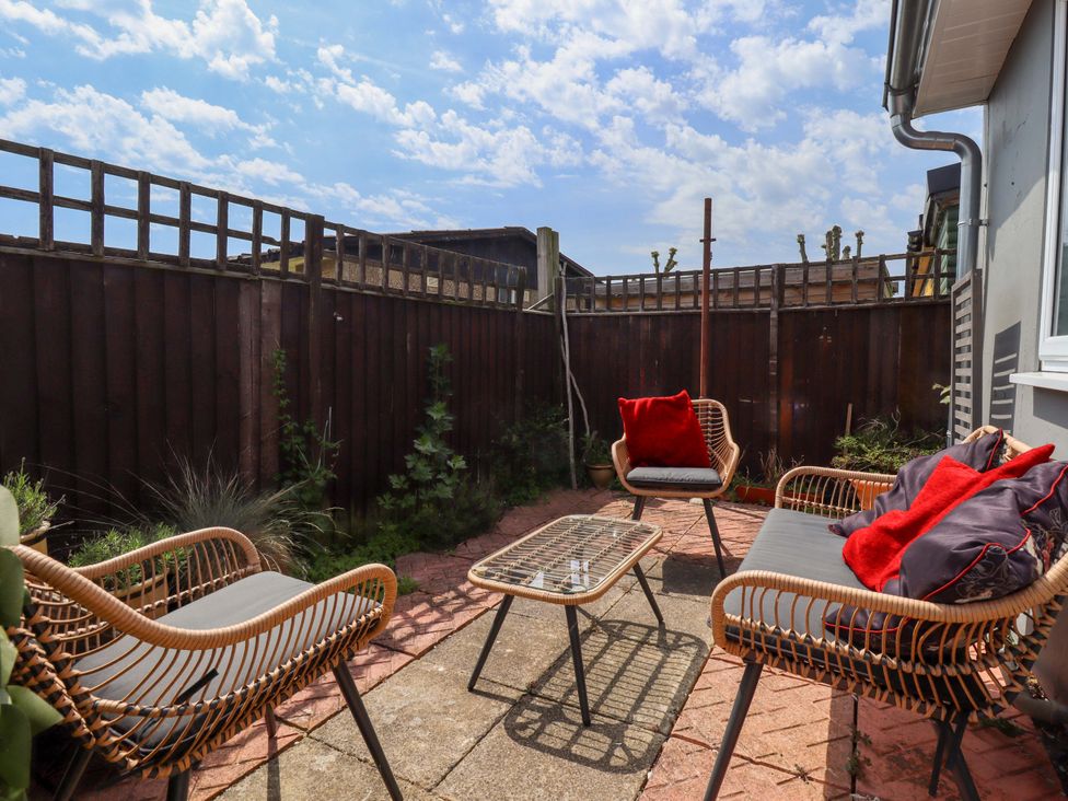 A garden with chairs and a table at Four Seasons in Humberston, Lincolnshire