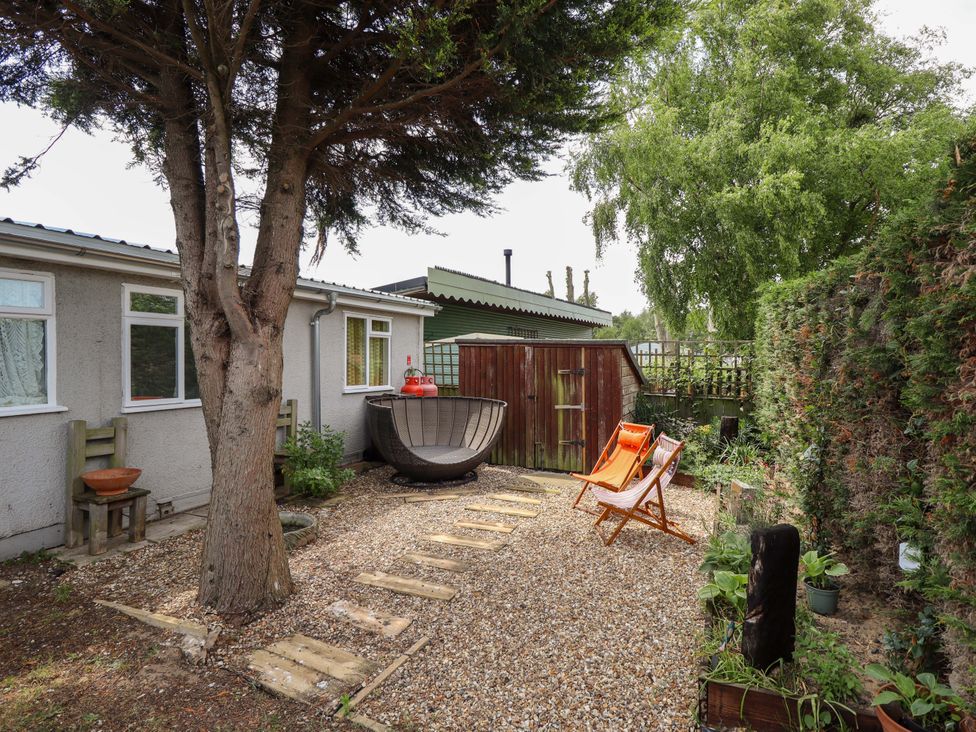 A garden with gravel path and seating at Four Seasons in Humberston, Lincolnshire