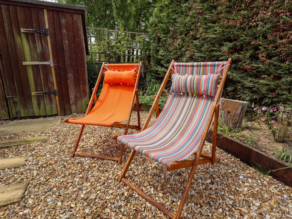 Two deck chairs and a garden shed in a gravel area at Four Seasons in Humberston, Lincolnshire