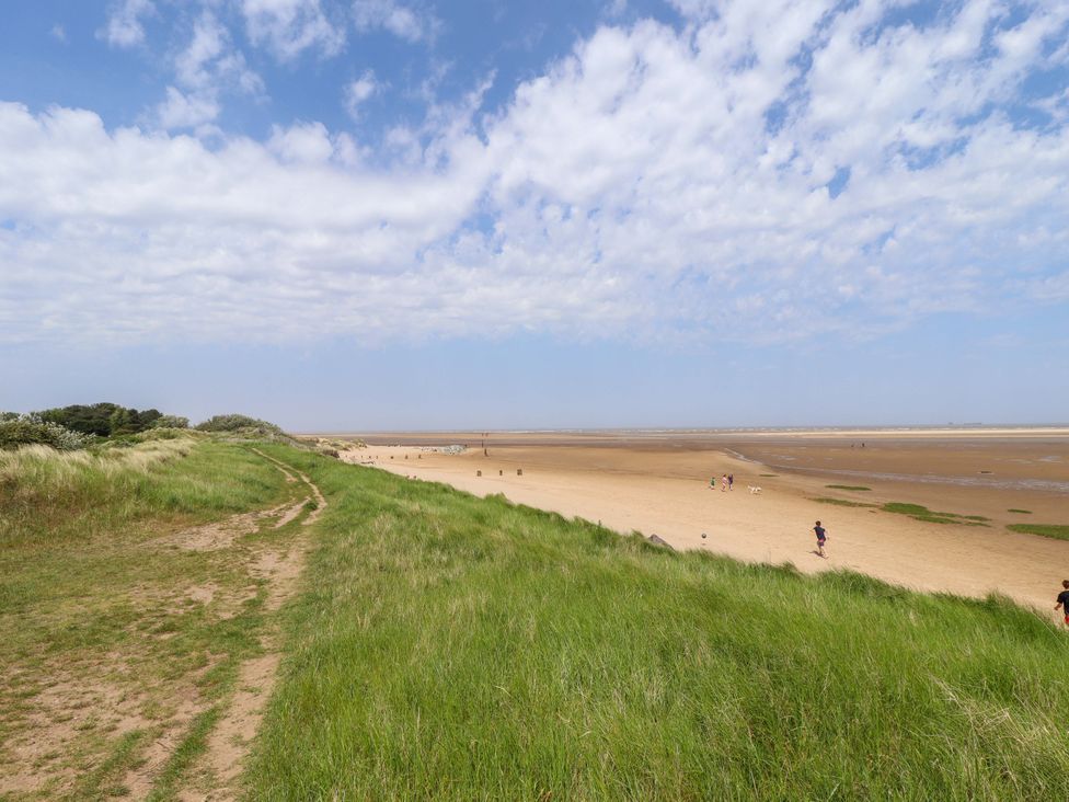 A beach with people walking at Four Seasons in Humberston, Lincolnshire