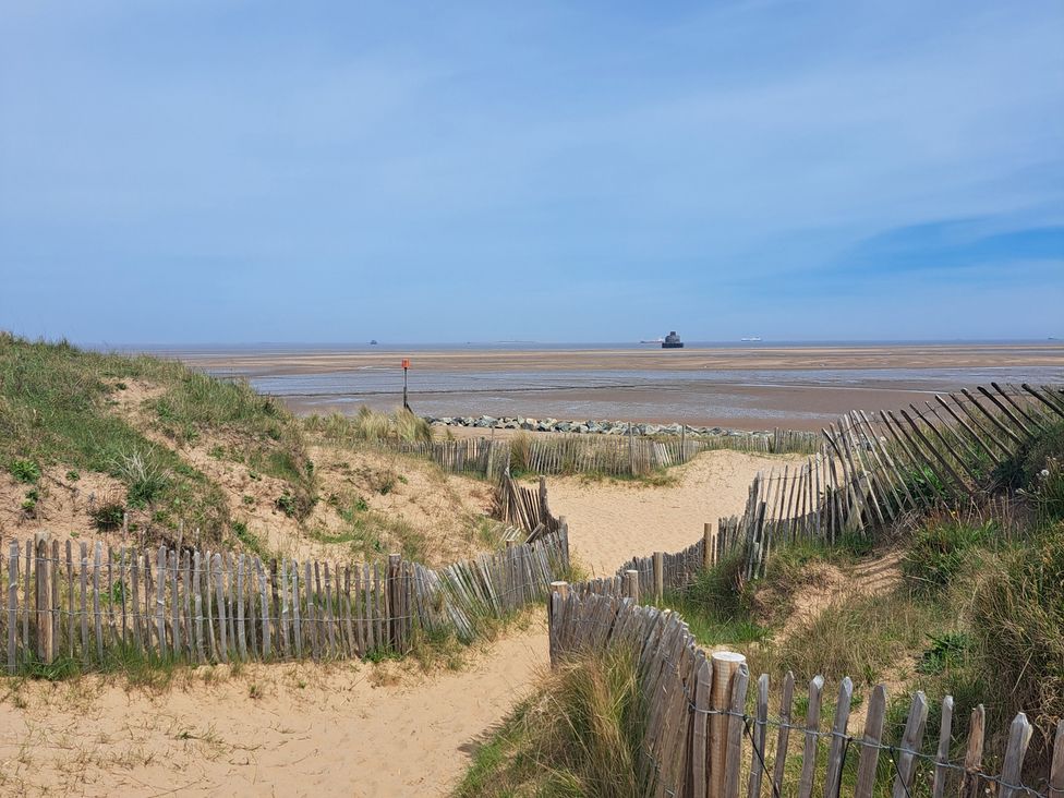 A pathway leading to a beach with sand and water at Four Seasons, Humberston, Lincolnshire