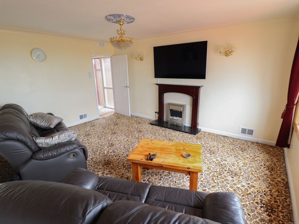 A living room with a television on the wall at Sandringham in Withernsea